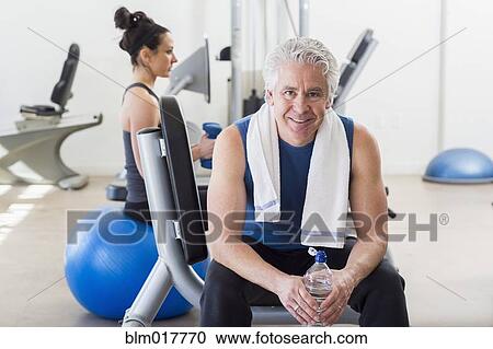 Stock Image - Older Hispanic man smiling in gym. Fotosearch