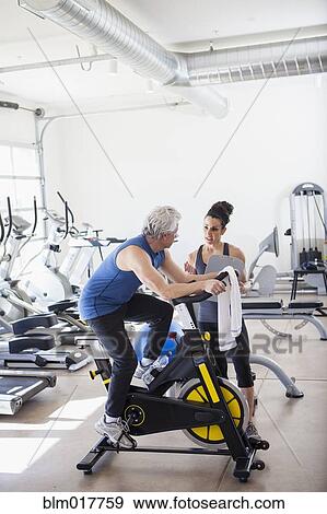 Older Hispanic man working with trainer in gym View Large Photo Image Stock Photo - Older Hispanic man working with trainer in gym. Fotosearch