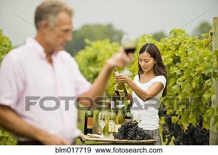 Stock Photo - People tasting wine in vineyard. Fotosearch