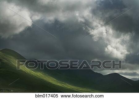 Stock Photography - Sun break in clouds in rural landscape. Fotosearch