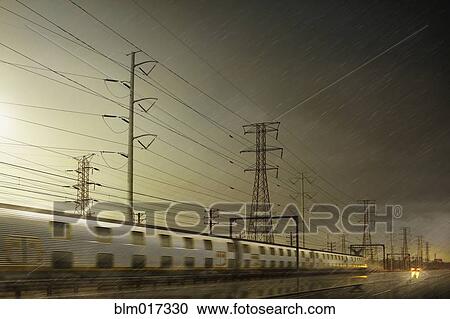 Stock Image - Train speeding by power lines. Fotosearch