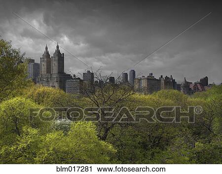 Stock Image - Urban park, skyscrapers and cloudy sky, New York, New York, United States. Fotosearch