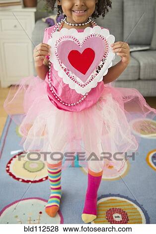 Stock Photo - African American girl holding Valentine's Day card. Fotosearch