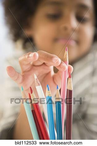 Stock Image - African American girl picking out colored pencil. Fotosearch