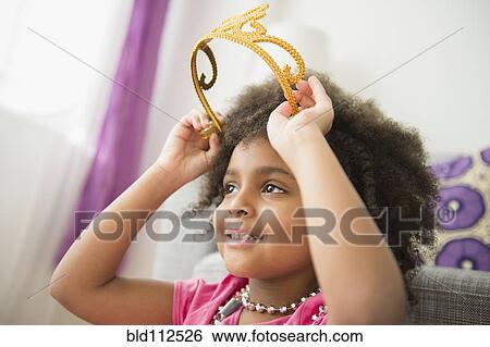 African American girl putting on toy crown View Large Photo Image Stock Photograph - African American girl putting on toy crown. Fotosearch