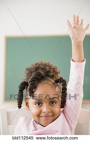 Stock Photography - African American girl raising her hand in classroom. Fotosearch
