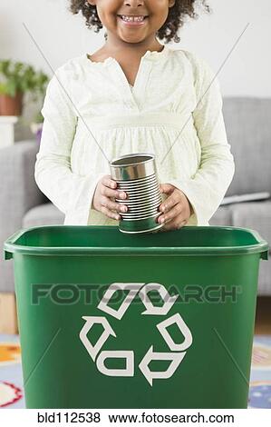 Stock Photo - African American girl recycling can. Fotosearch