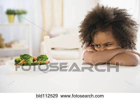 African American girl refusing vegetables at table View Large Photo Image Stock Photo - African American girl refusing vegetables at table. Fotosearch