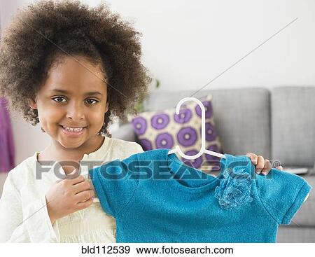 Stock Photo - African American girl showing new shirt. Fotosearch