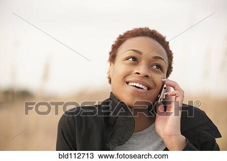 Stock Image - African American woman talking on cell phone. Fotosearch
