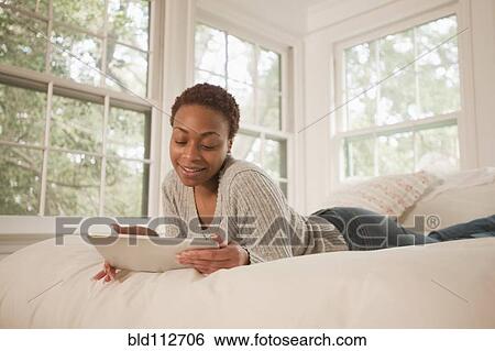 African American woman using digital tablet in bed View Large Photo Image Stock Photograph - African American woman using digital tablet in bed. Fotosearch