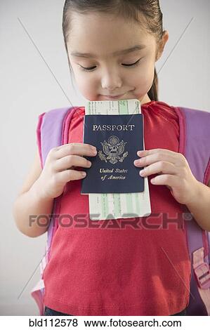 Stock Photo - Asian girl holding airplane ticket and passport. Fotosearch