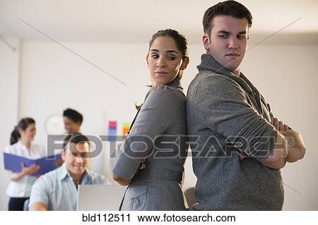 Business people standing back to back in office View Large Photo Image Stock Image - Business people standing back to back in office. Fotosearch