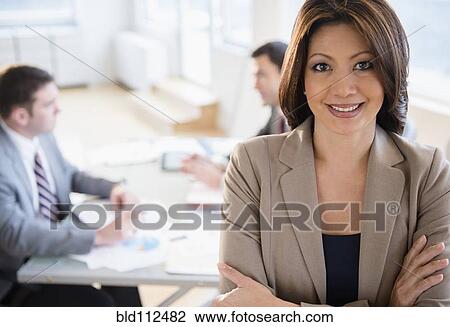 Stock Image - Businesswoman smiling in office. Fotosearch