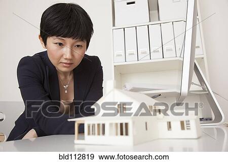 Stock Photo - Businesswoman working on model in office. Fotosearch