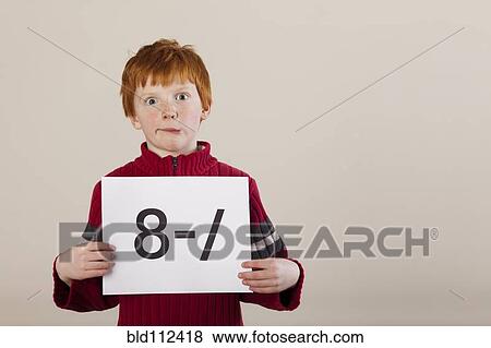 Caucasian boy holding card with awkward face View Large Photo Image Stock Photo - Caucasian boy holding card with awkward face. Fotosearch