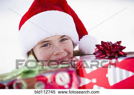 Caucasian boy in Santa hat holding Christmas presents View Large Photo Image Stock Photography - Caucasian boy in Santa hat holding Christmas presents. Fotosearch