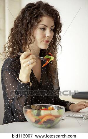 Caucasian businesswoman eating salad at desk View Large Photo Image Stock Photo - Caucasian businesswoman eating salad at desk. Fotosearch