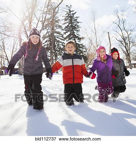 Stock Photo - Caucasian children walking in snow outdoors. Fotosearch