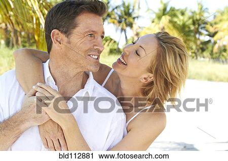Stock Image - Caucasian couple hugging outdoors. Fotosearch