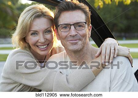 Caucasian couple smiling by car View Large Photo Image Stock Photography - Caucasian couple smiling by car. Fotosearch