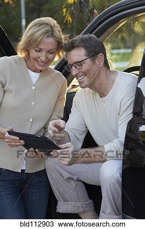 Stock Image - Caucasian couple using digital tablet in car. Fotosearch