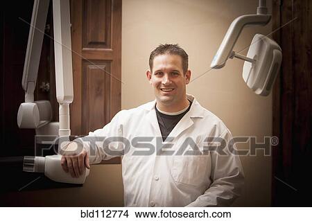Picture - Caucasian dentist smiling in office. Fotosearch