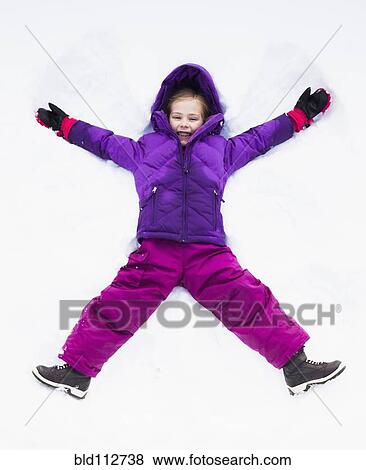 Stock Photo - Caucasian girl making snow angel outdoors. Fotosearch