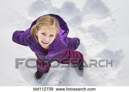 Caucasian girl making snow angel outdoors View Large Photo Image Stock Photo - Caucasian girl making snow angel outdoors. Fotosearch