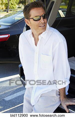 Caucasian man sitting in trunk of car View Large Photo Image Stock Image - Caucasian man sitting in trunk of car. Fotosearch