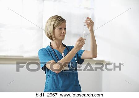 Caucasian nurse filling syringe View Large Photo Image Stock Photo - Caucasian nurse filling syringe. Fotosearch