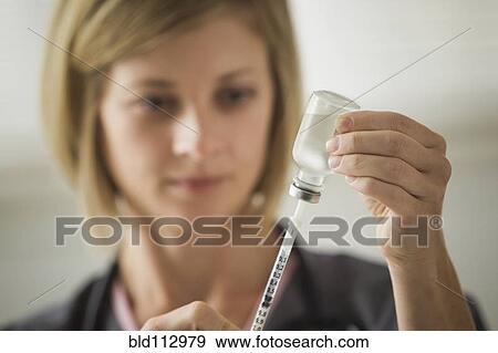 Caucasian nurse filling syringe View Large Photo Image Stock Photo - Caucasian nurse filling syringe. Fotosearch
