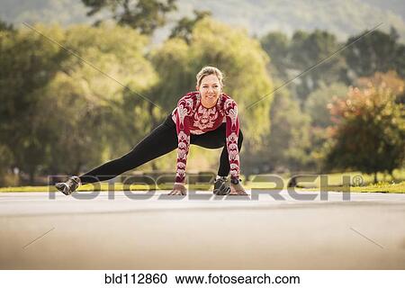 Caucasian runner stretching in park View Large Photo Image Stock Image - Caucasian runner stretching in park. Fotosearch