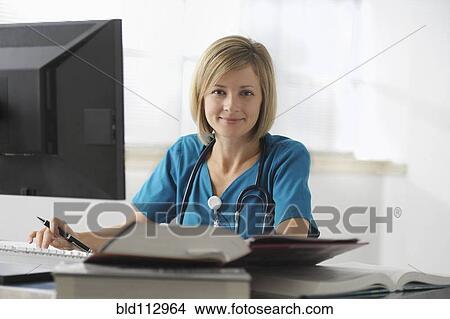 Caucasian surgeon reading books and using computer View Large Photo Image Picture - Caucasian surgeon reading books and using computer. Fotosearch