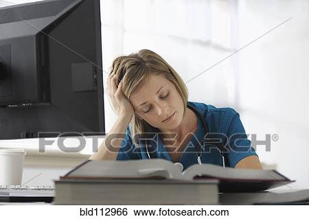 Caucasian surgeon reading books and using computer View Large Photo Image Stock Photograph - Caucasian surgeon reading books and using computer. Fotosearch