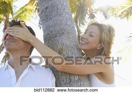 Caucasian woman covering boyfriend's eyes View Large Photo Image Stock Image - Caucasian woman covering boyfriend's eyes. Fotosearch