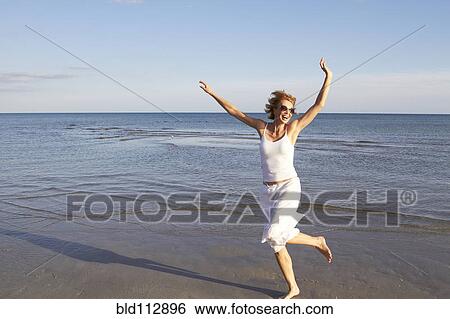 Stock Photograph - Caucasian woman playing on beach. Fotosearch