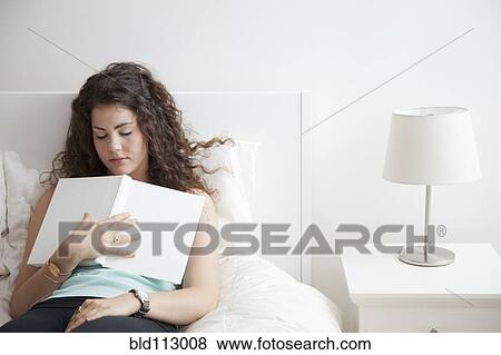 Caucasian woman sleeping in bed holding book View Large Photo Image Stock Photo - Caucasian woman sleeping in bed holding book. Fotosearch