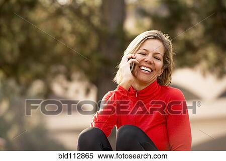 Stock Photography - Caucasian woman talking on cell phone outdoors. Fotosearch