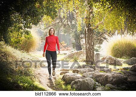 Caucasian woman walking on path View Large Photo Image Stock Photograph - Caucasian woman walking on path. Fotosearch