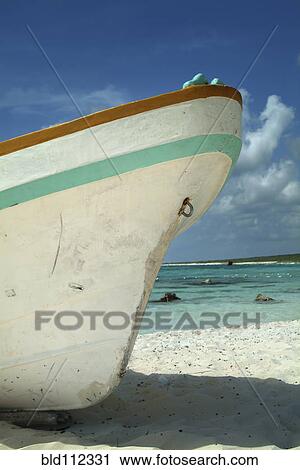 Stock Image - Close up of boat docked on sandy beach. Fotosearch