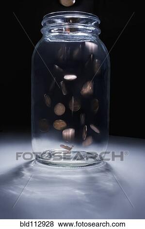 Coins falling into empty change jar View Large Photo Image Stock Photo - Coins falling into empty change jar. Fotosearch