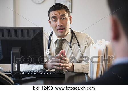 Stock Photo - Doctor talking to clients in office. Fotosearch