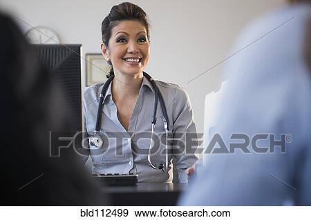Stock Photo - Doctor talking to clients in office. Fotosearch