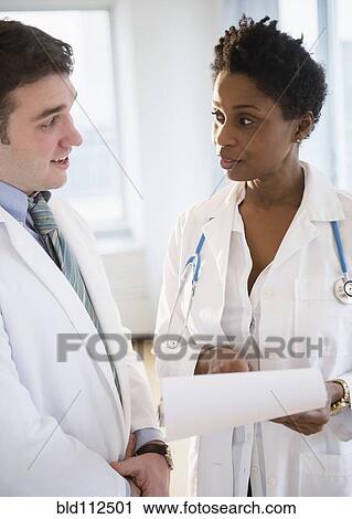 Stock Image - Doctors talking in office. Fotosearch