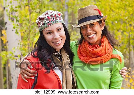 Stock Photo - Friends hugging in forest. Fotosearch