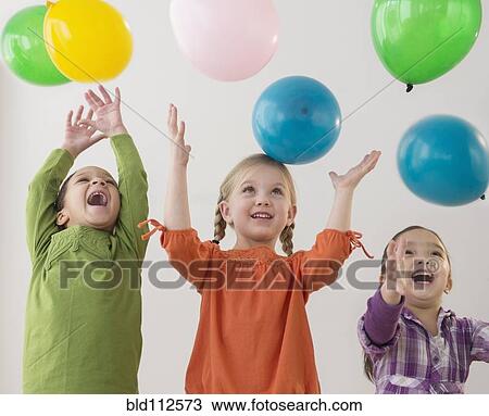 Stock Image - Girls playing with balloons. Fotosearch
