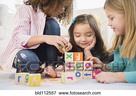 Girls playing with colorful blocks in living room View Large Photo Image Stock Photo - Girls playing with colorful blocks in living room. Fotosearch