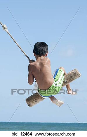 Hispanic boy playing on swing outdoors View Large Photo Image Picture - Hispanic boy playing on swing outdoors. Fotosearch