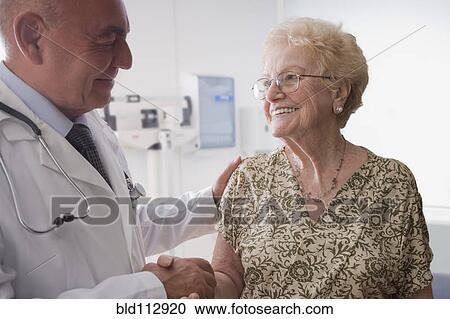 Hispanic doctor talking with older patient View Large Photo Image Stock Image - Hispanic doctor talking with older patient. Fotosearch